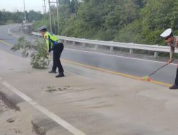 Jaga Keselamatan Pengendara, Personil Satlantas Polres Bintan Bersihkan Tumpahan Pasir di Jalan Lintas Barat